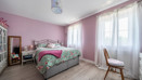 Bedroom with double bed, chair, and windows with curtains.