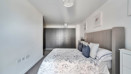 Bedroom with double bed, bedside tables and fitted wardrobe doors.
