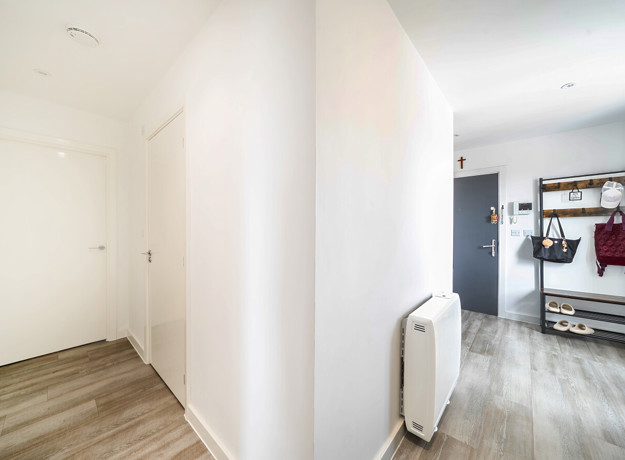 Entrance hallway with wood-effect flooring and storage space.