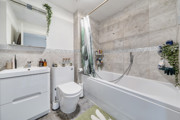 Bathroom with bath, shower, toilet, and vanity unit.