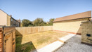 Enclosed rear garden with lawn and gravel area.