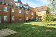 Communal garden with lawn area surrounded by brick apartment buildings