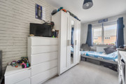 Bedroom with children's bed, wardrobe, dresser, and window with blinds.
