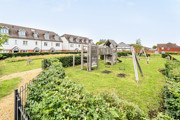 Residential area with grass, play structure and houses in background.