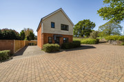 Detached modern house with brick and wood exterior and driveway