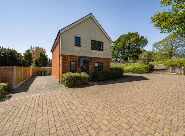 Detached modern house with brick and wood exterior and driveway