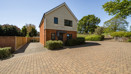 Detached modern house with brick and wood exterior and driveway