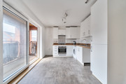 Kitchen with fitted units, integrated oven and sliding balcony doors.