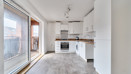 Kitchen with fitted units, integrated oven and sliding balcony doors.