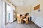 Dining area with a table, chairs and patio doors.