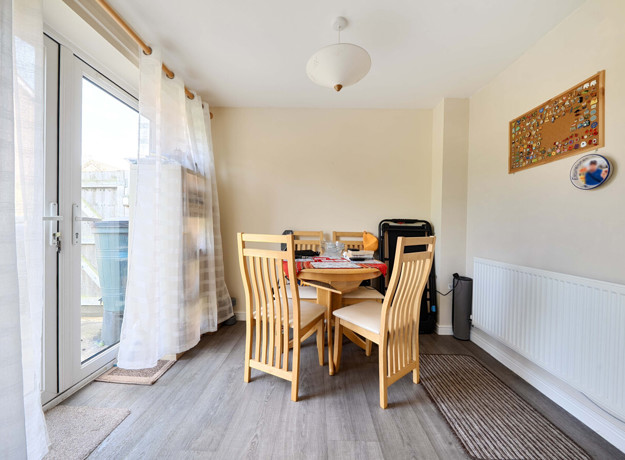 Dining area with a table, chairs and patio doors.