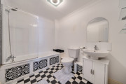 Bathroom with bath, toilet, sink and mirrored cabinet.