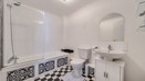Bathroom with bath, toilet, sink and mirrored cabinet.