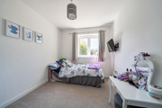 Compact bedroom with single bed, desk and window