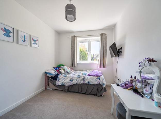 Compact bedroom with single bed, desk and window