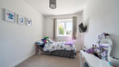Compact bedroom with single bed, desk and window