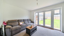 Living room with sofa, coffee table, and patio doors to the garden.