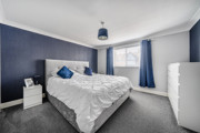 Bedroom with double bed, bedside tables, wardrobe and window.