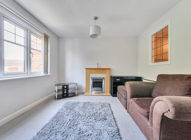 iving room with sofas, rug, fireplace and window.