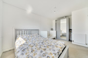 Bedroom with double bed, cot, and wardrobe with mirrored doors.