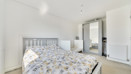 Bedroom with double bed, cot, and wardrobe with mirrored doors.